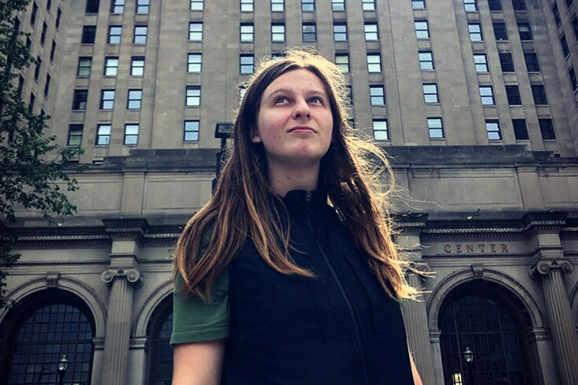Amy Piero stands in front of a large concrete building