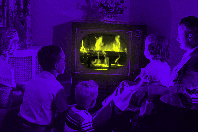 1950s family watching a log burn in a fireplace on TV